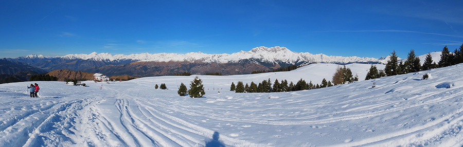 Salendo al Monte Alto vista panoramica sul Rif. Magnolini e le Orobie con la Presolana dominante